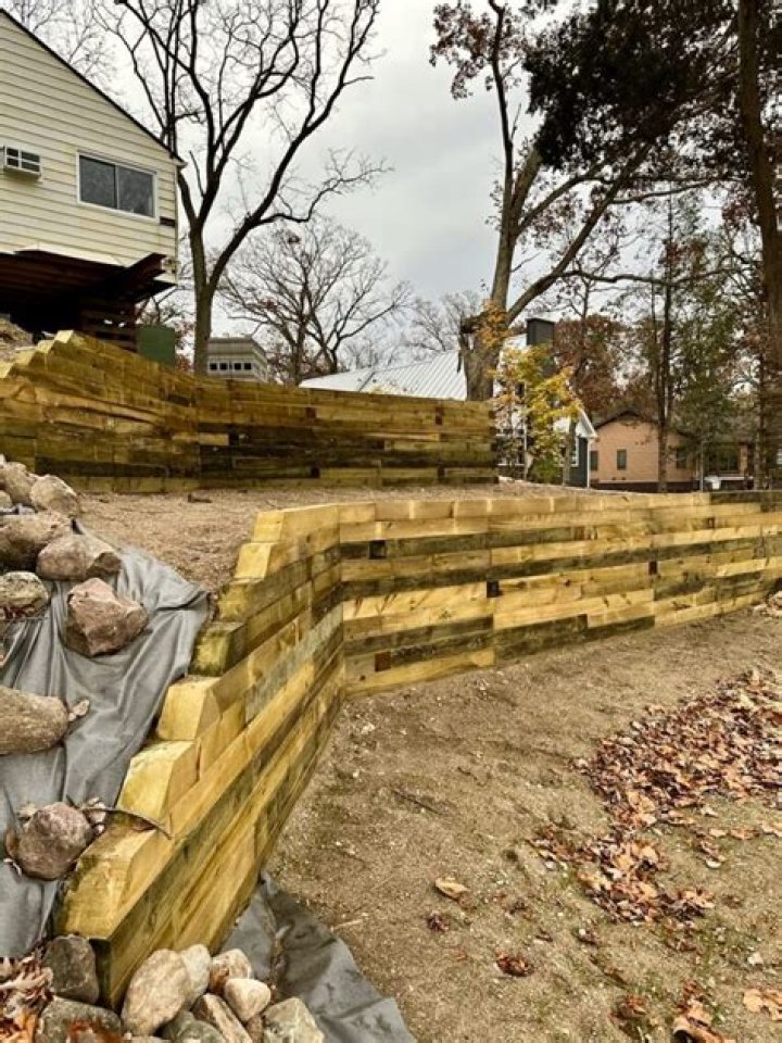 How do you landscape a retaining wall timber?