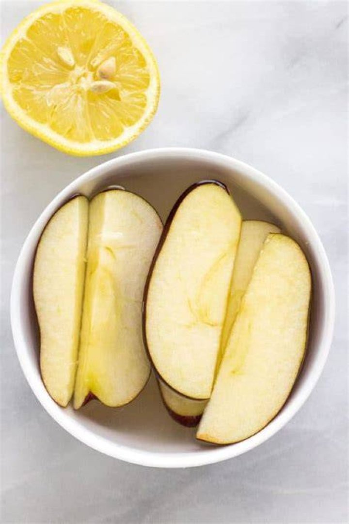 How does lemon juice keep apples from turning brown?
