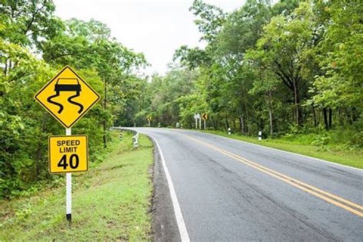 What is the best way to prevent skidding on a slippery road surface?
